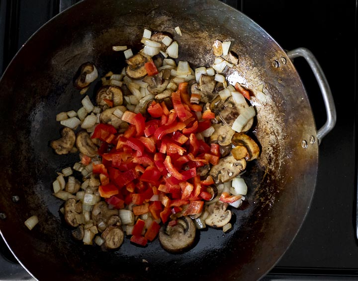 onions, mushrooms and red pepper in a wok
