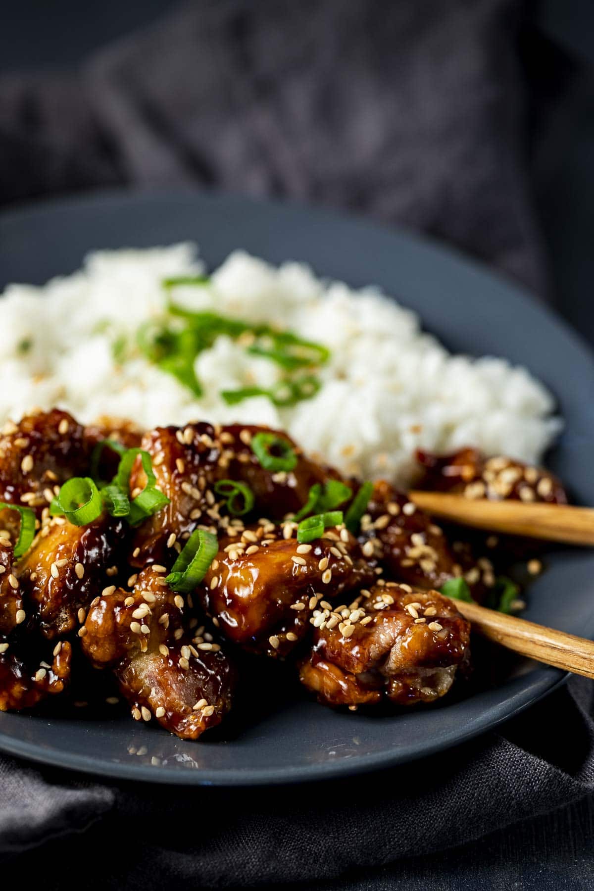 Close up view of sesame chicken with a side of white rice.