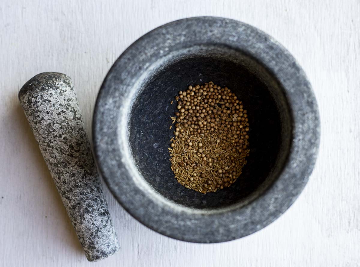 ground spices in a mortar with pestle on the side
