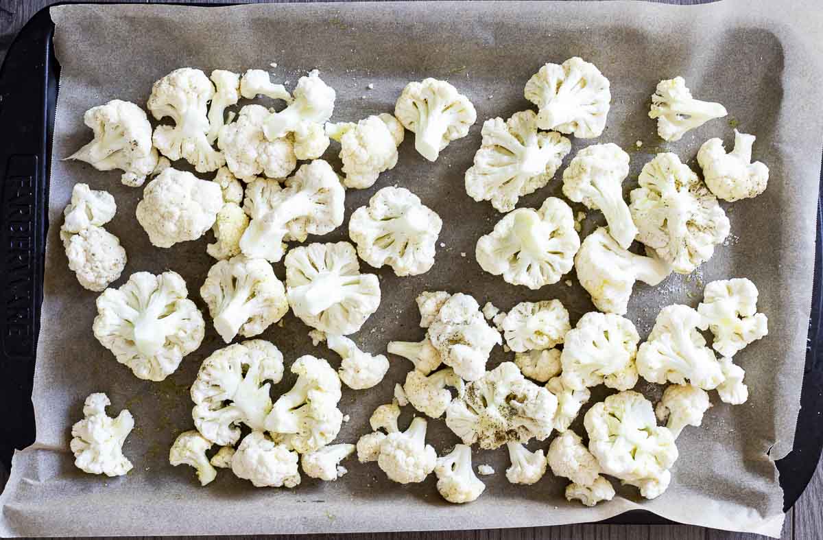 raw cauliflower on a parchment lined baking sheet