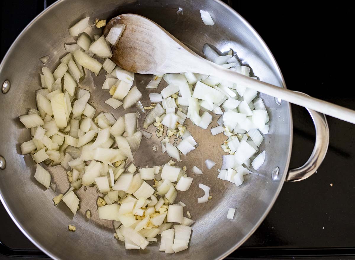 diced onions being sauteed in a skillet