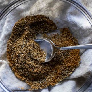 a bowl of brown spices with a spoon