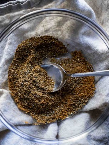 a bowl of brown spices with a spoon