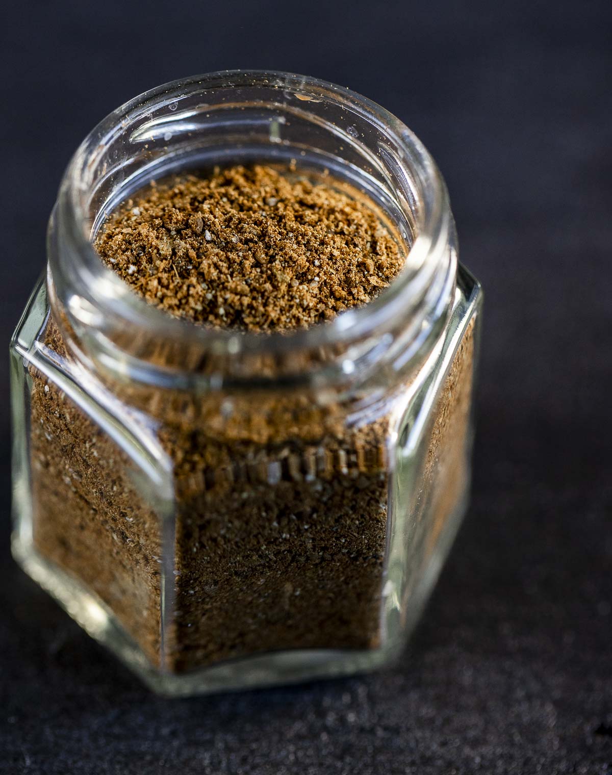 a glass jar of ground brown spices
