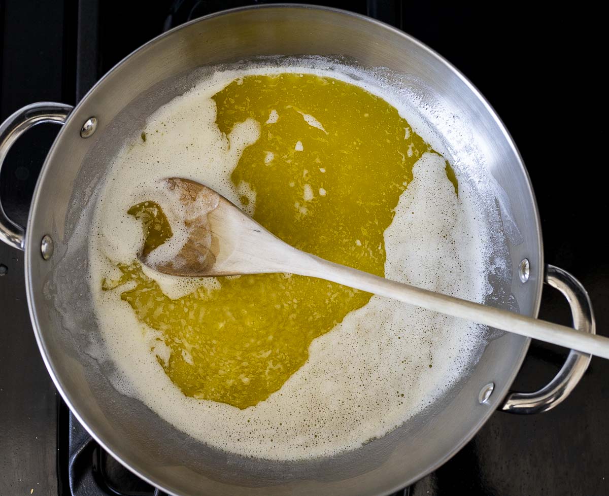 butter melting in a skillet with a wooden spoon