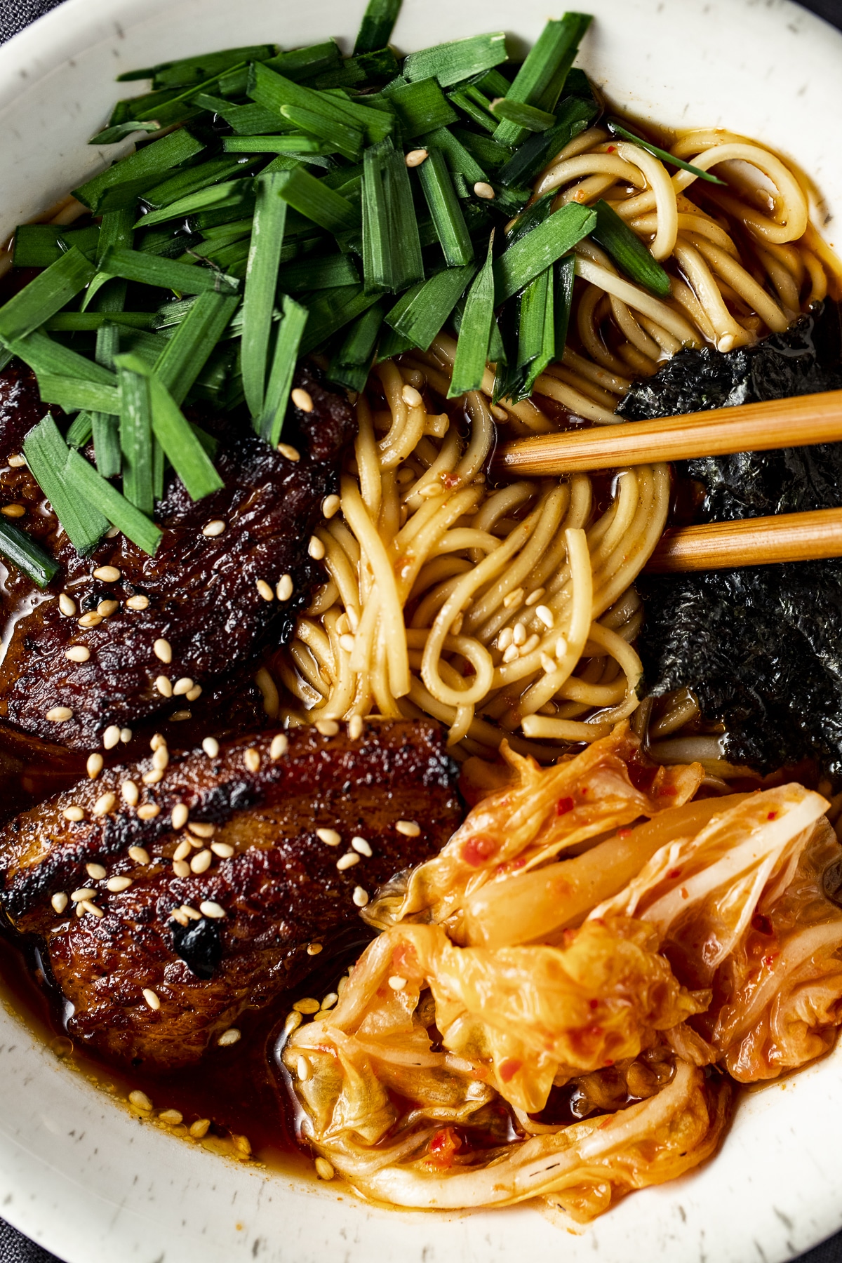 Close up view of pork belly and other toppings on the Korean ramen.