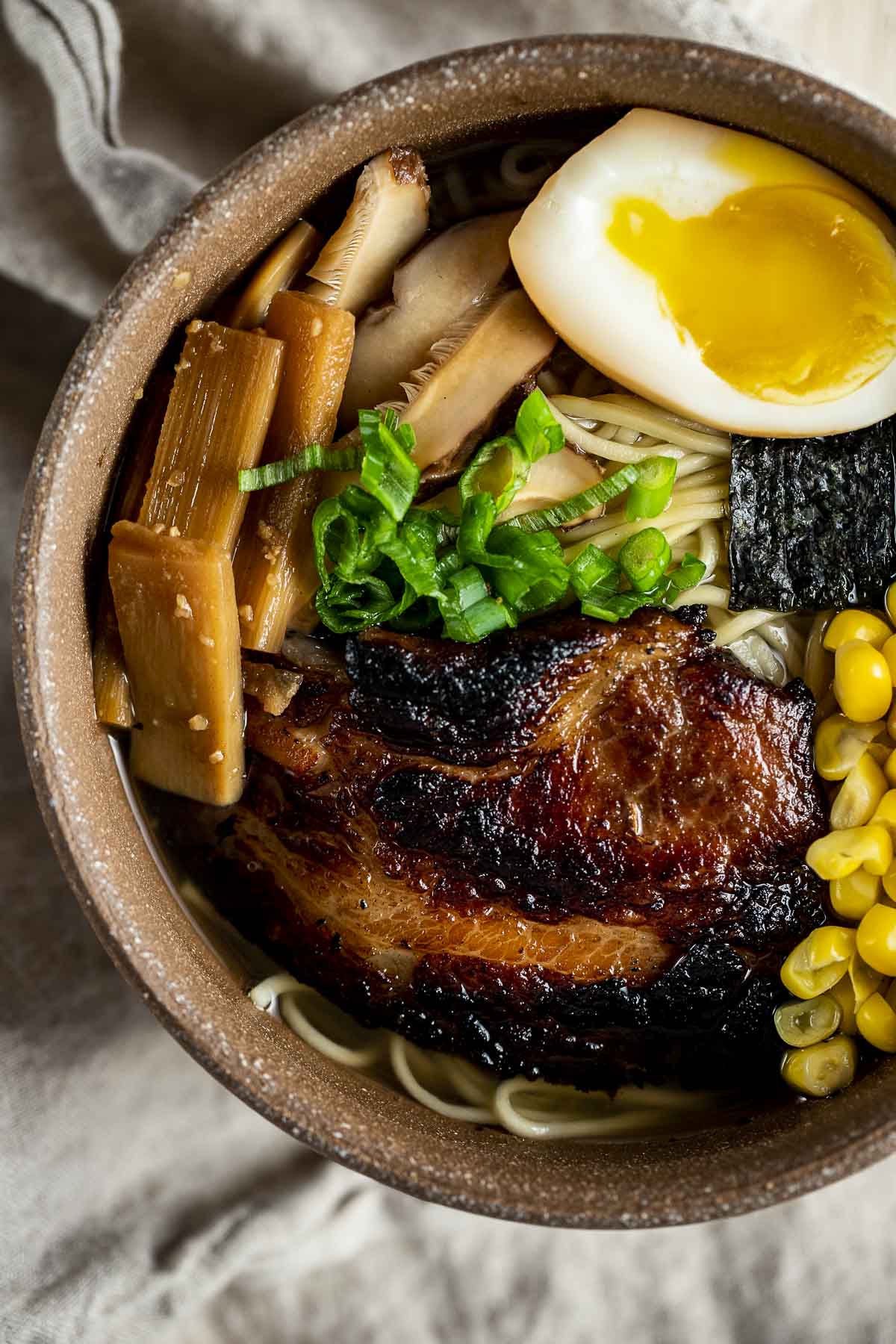 Close up of braised pork, ramen egg and menma in a bowl of shio ramen.