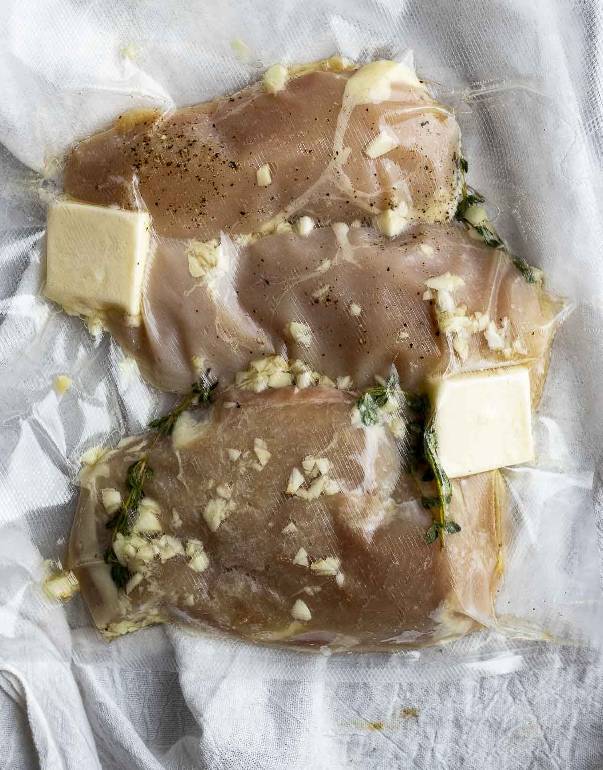 Chicken breasts, butter and seasonings sealed in a bag.