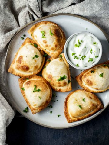 pierogies on a plate with sour cream