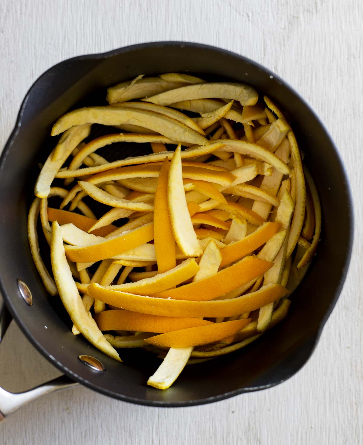 sliced orange peels in a saucepan