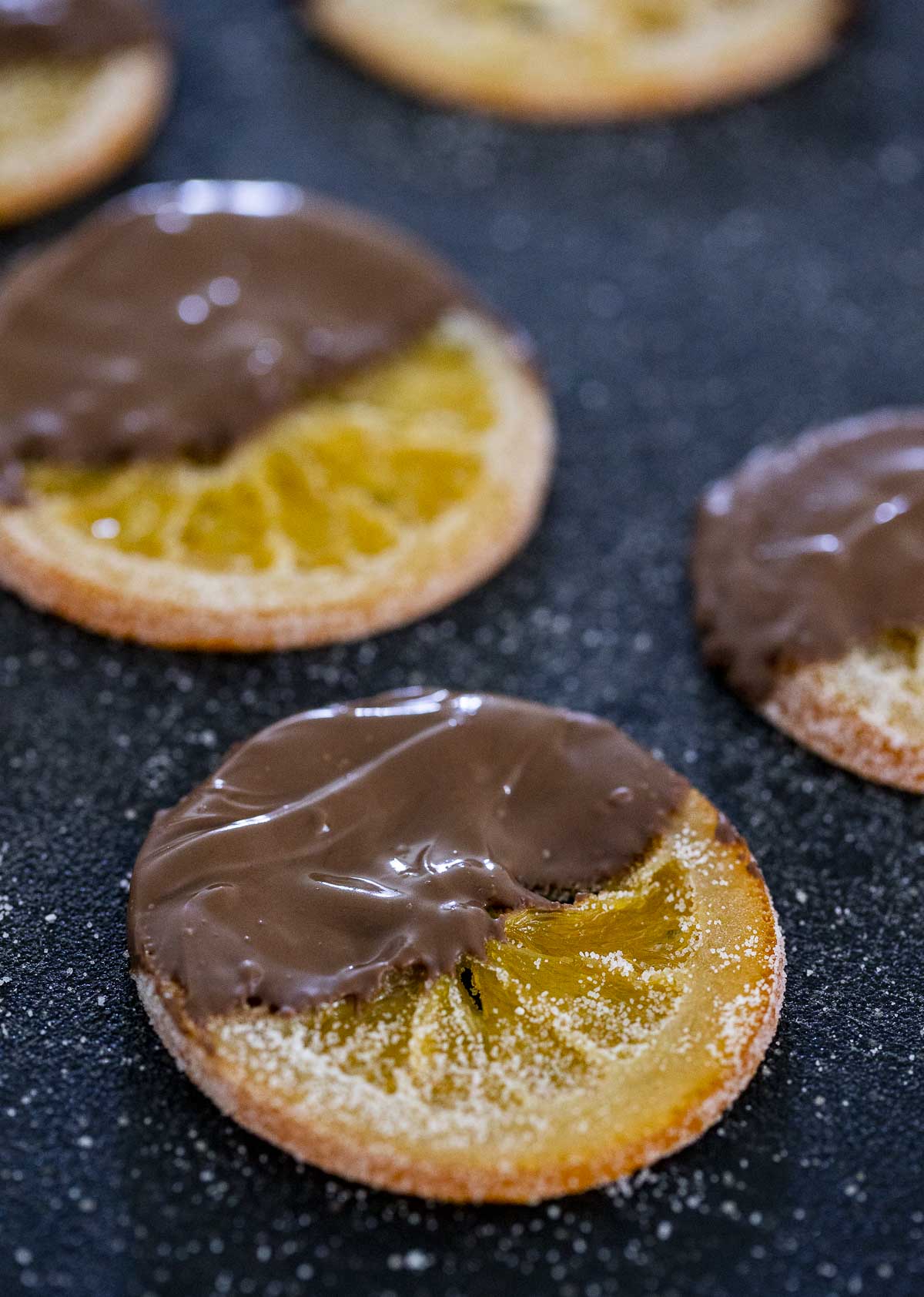 Chocolate dipped orange slices arranged flat to dry.
