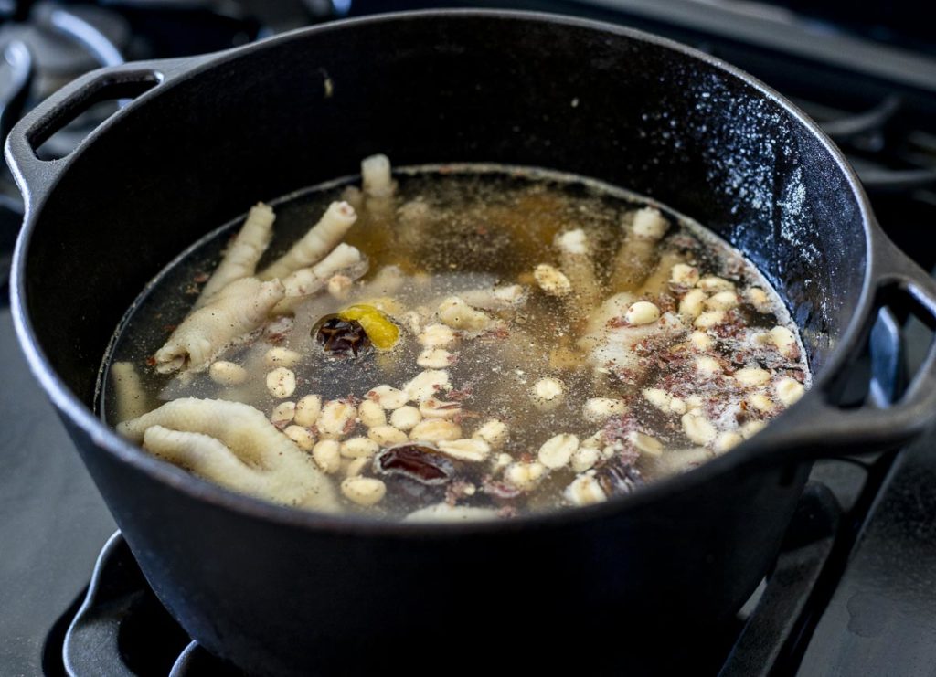 a pot with chicken feet and broth in it