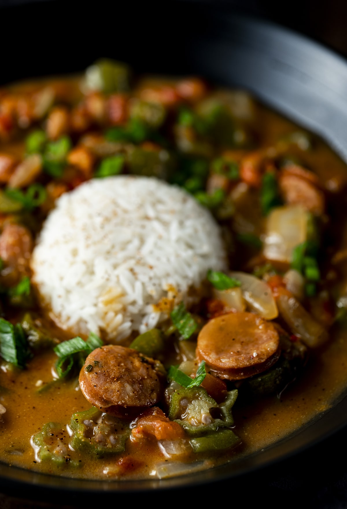 Side view of crawfish gumbo in a bowl with a scoop of rice.