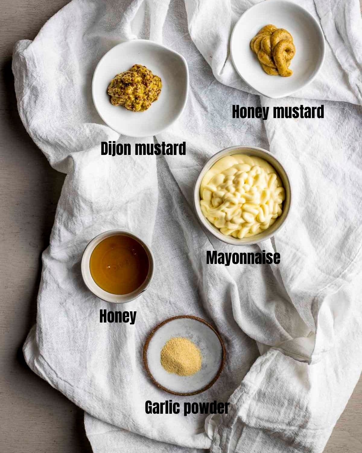 Ingredients to make creamy dijon sauce arranged individually and labelled.