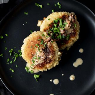 2 fried risotto cakes on a plate garnished with parsley