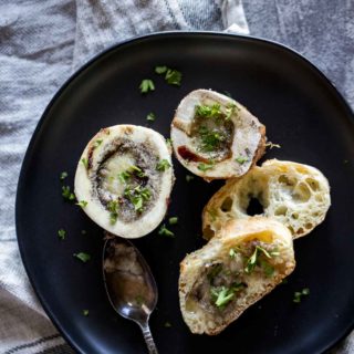 bone marrow bones sprinkled with parsley on a plate with bread