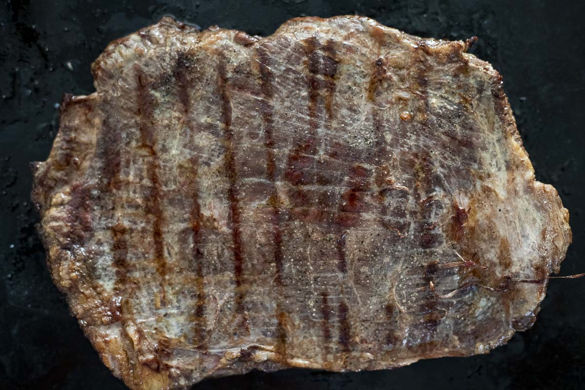 a seared flank steak on a flat surface