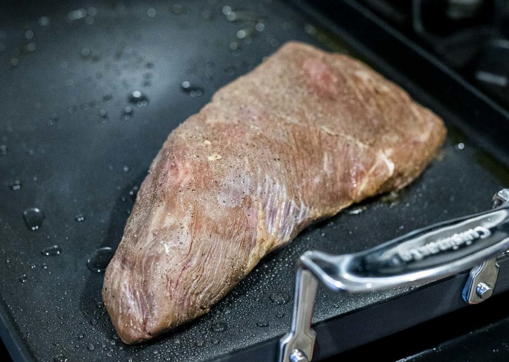 tri tip steak cooking on a griddle