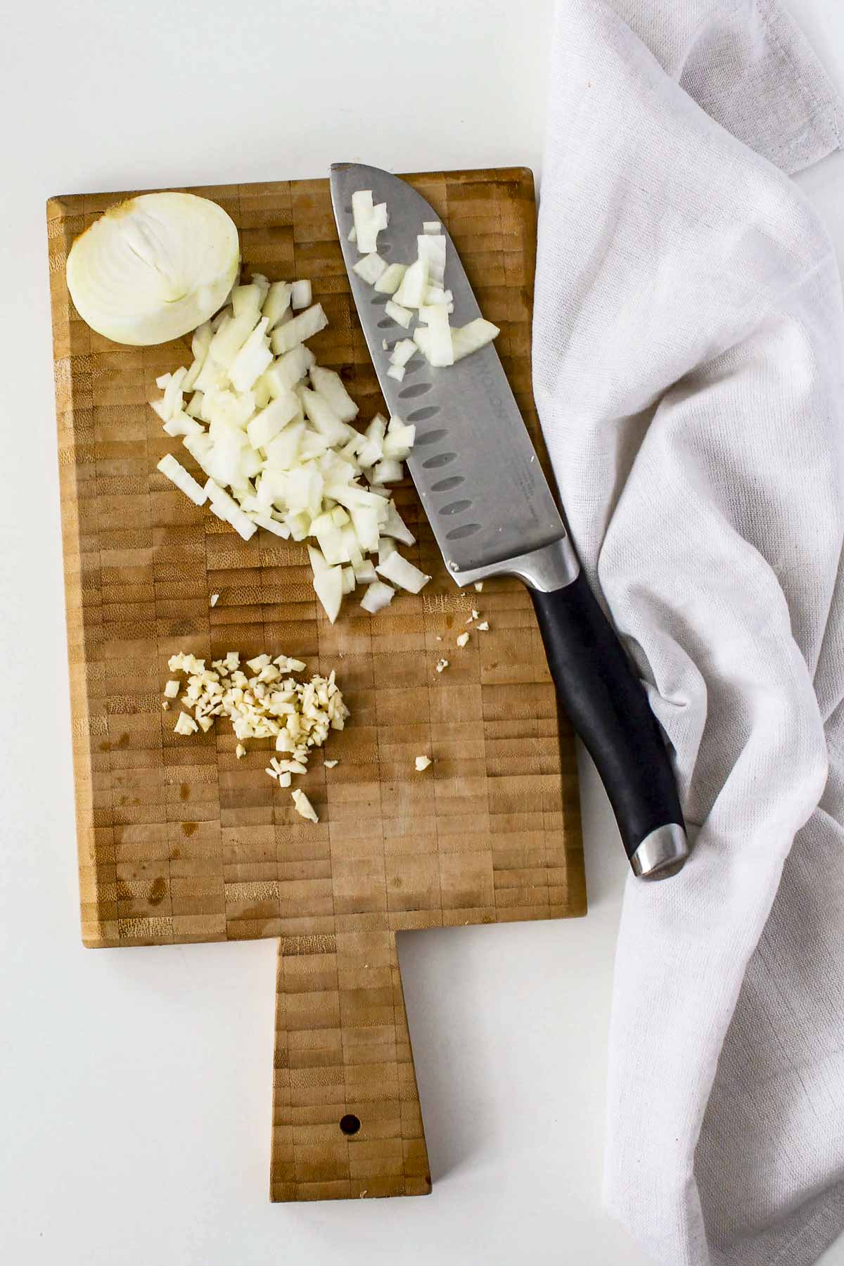 Diced onions and garlic on a cutting board.
