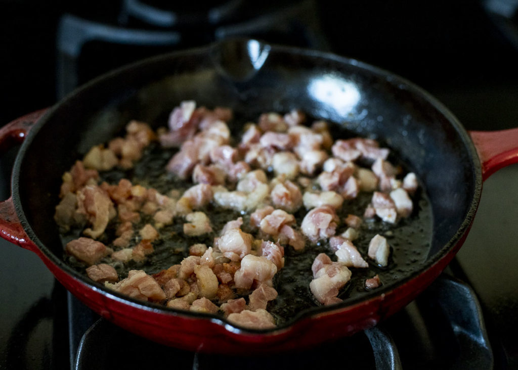 diced pancetta frying in a skillet