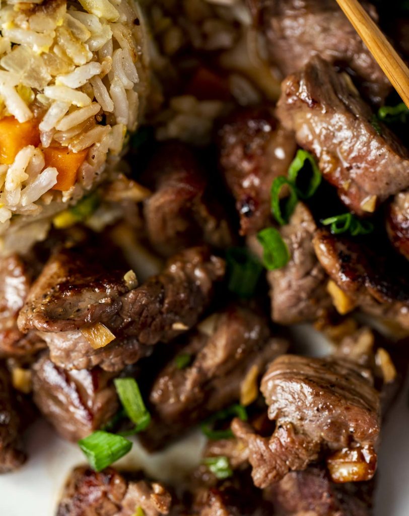 seared beef pieces with green onions and rice on the side