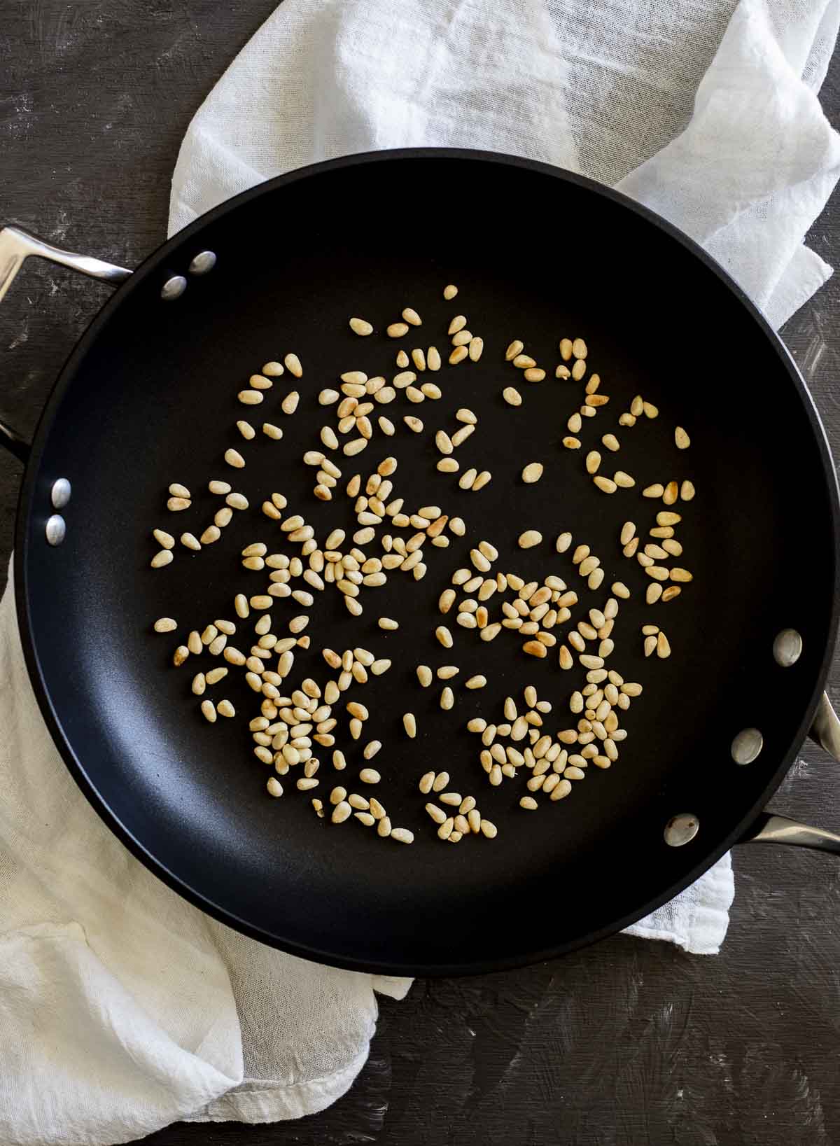 Toasting pinenuts in a skillet.