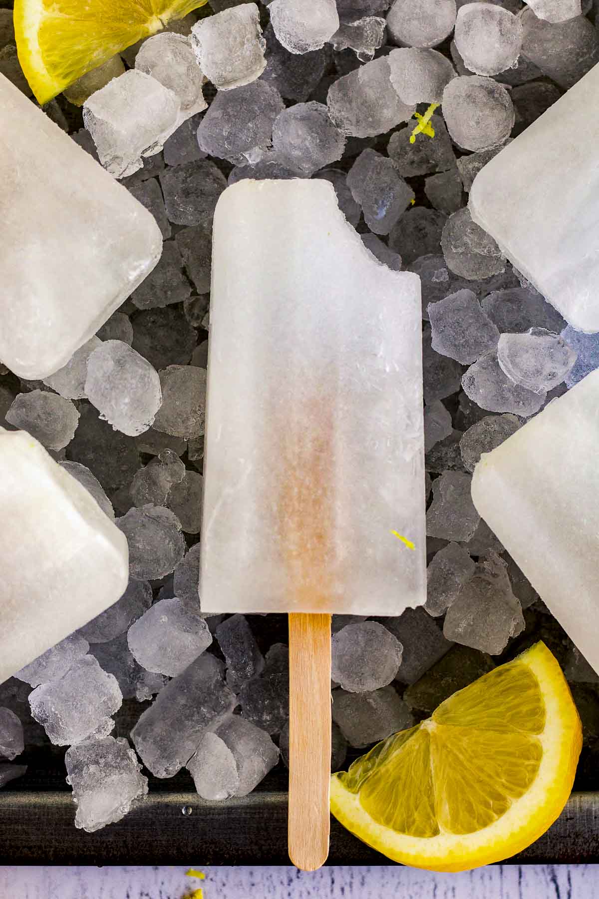 A lemonade popsicle with a bite taken out of it.