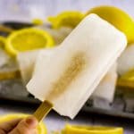 Hand holding a lemonade popsicle.