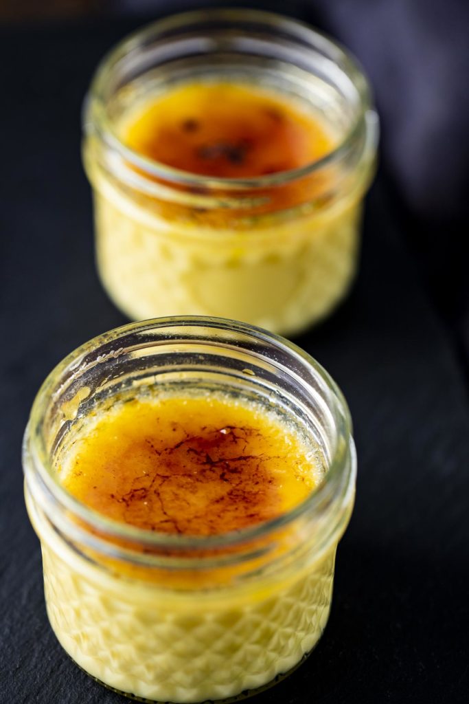 2 glass jars of creme brulee with caramelized tops