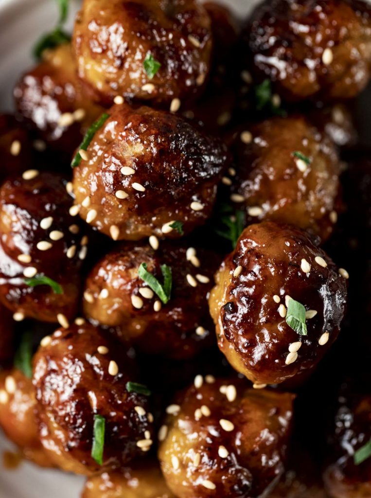 cooked glazed meatballs with sesame garnished with green onions