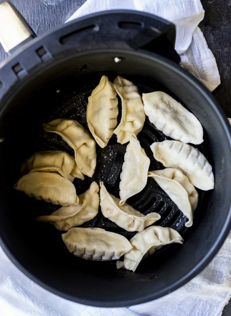 uncooked potstickers in a pan in a single layer