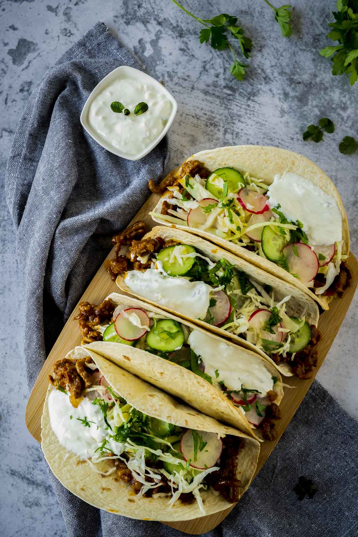 Overhead view of spicy lamb tacos on a serving board.