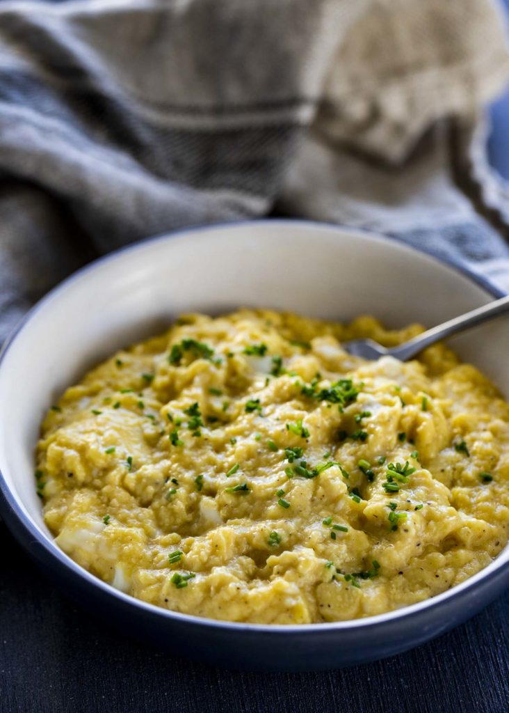 scrambled eggs in a bowl garnished with chives