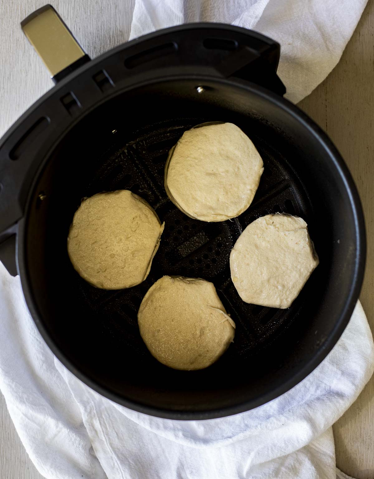 Biscuit dough added to an air fryer basket.