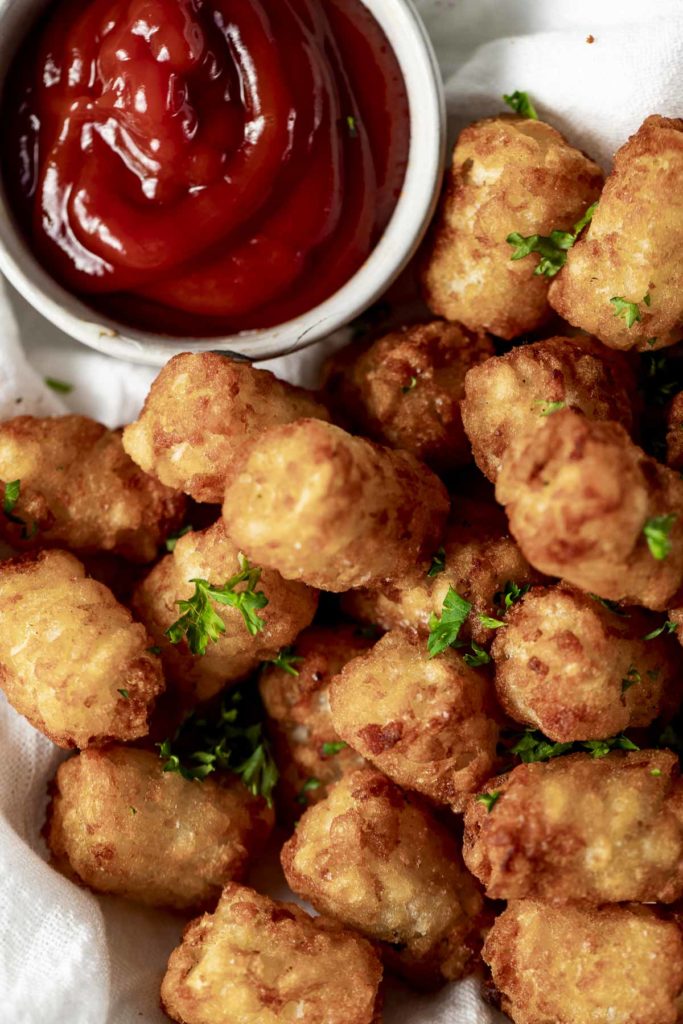A serving of air fryer tater puffs with ketchup on the side.