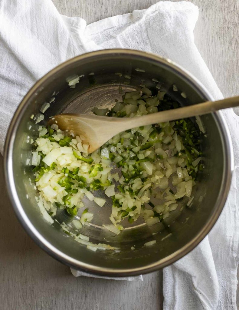 Sautéing onion, garlic and jalapeno in a pressure cooker liner.