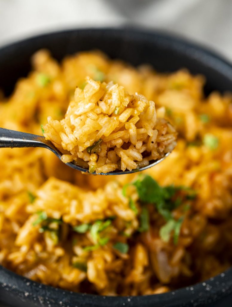 A close up of a spoonful of Spanish rice.