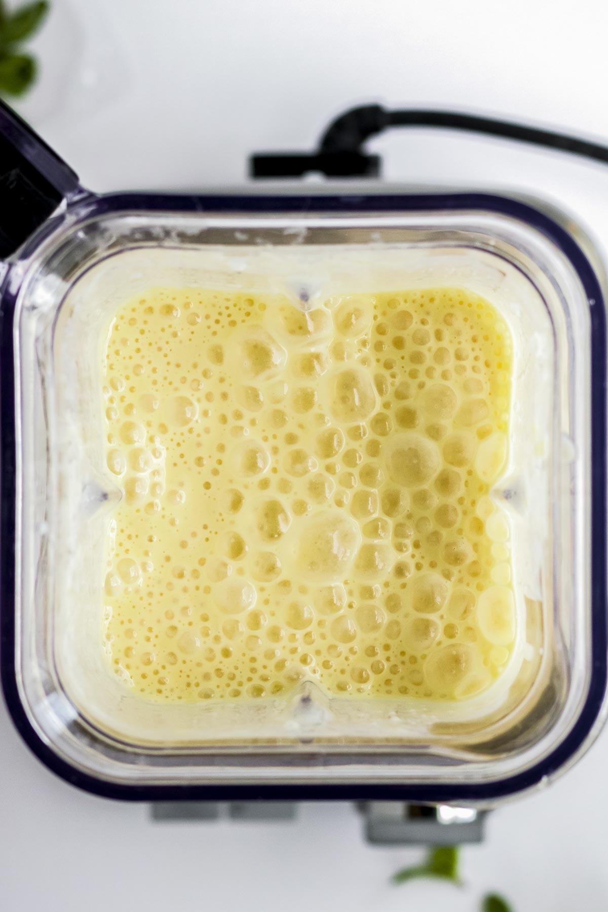 Overhead view of blender filled with orange creamsicle mixture.