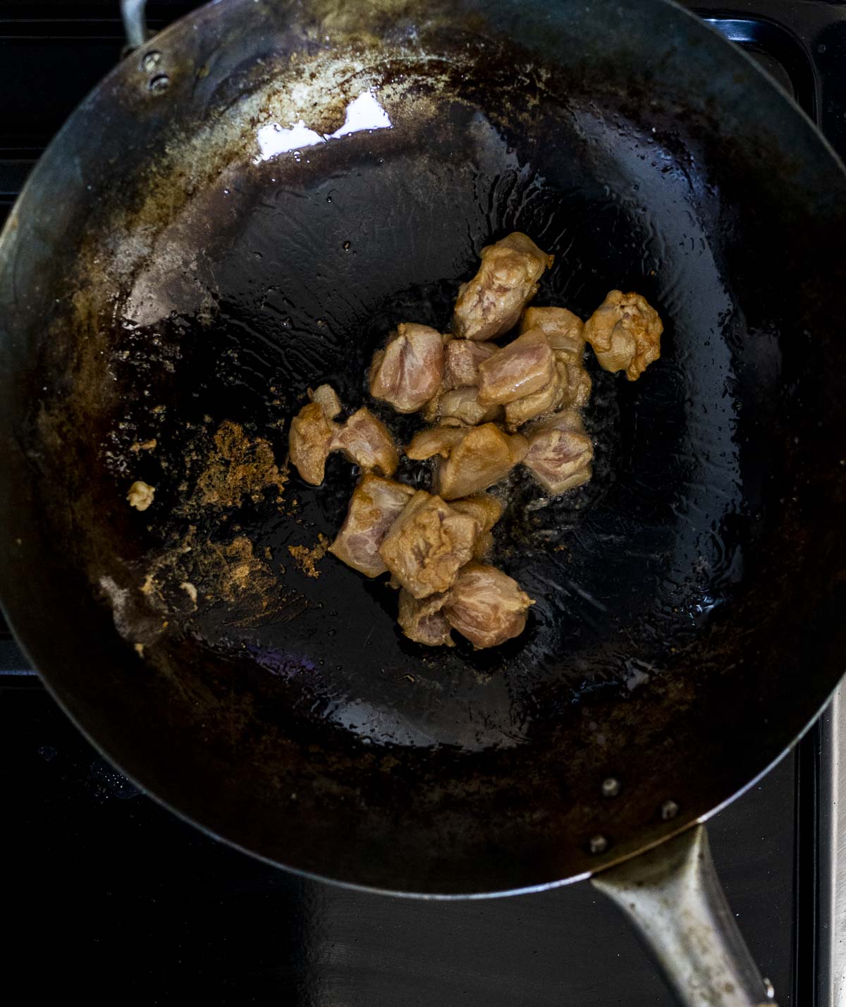 Cooking marinated chicken in a wok.