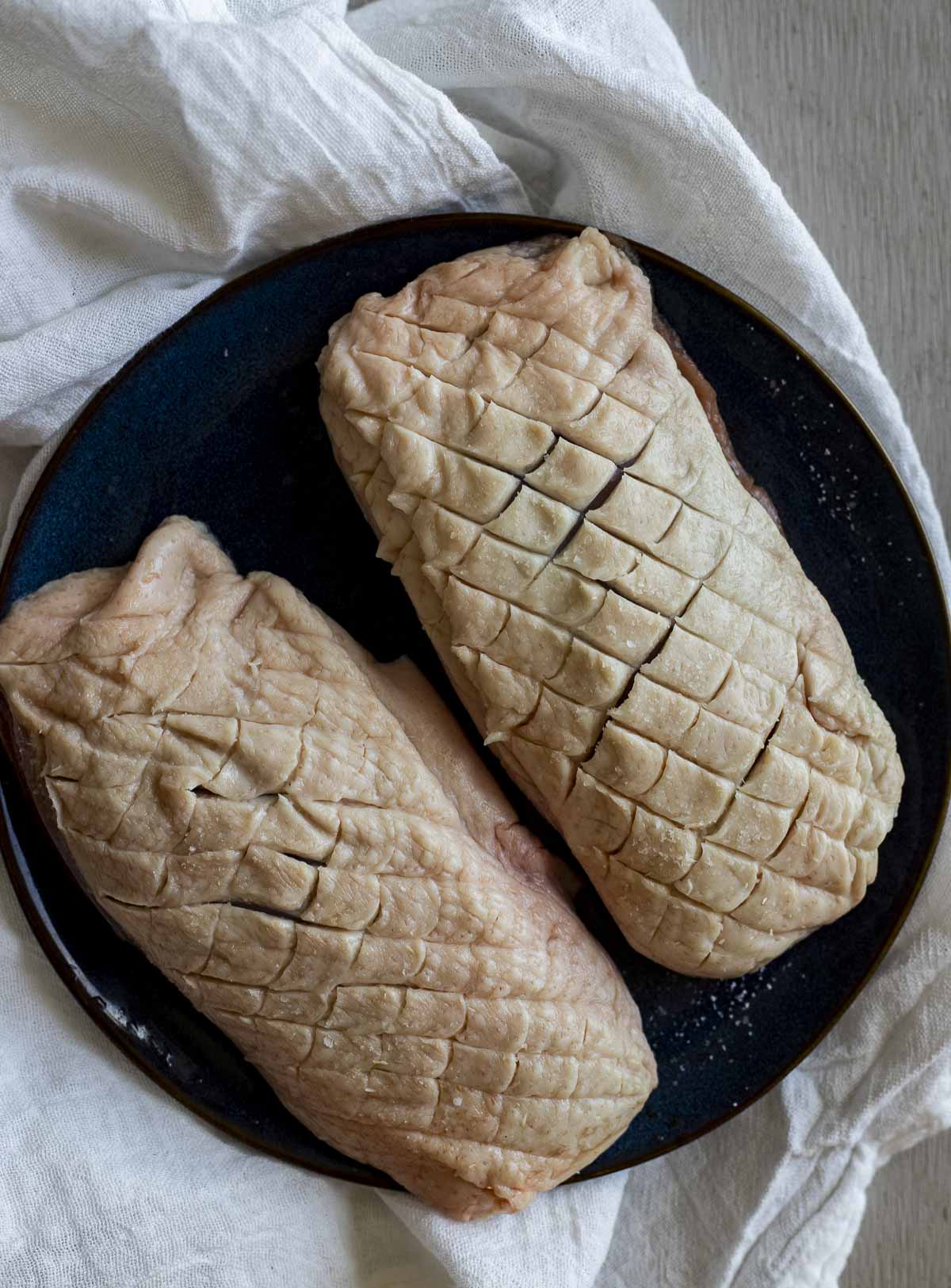 Duck breasts with their skin scored.