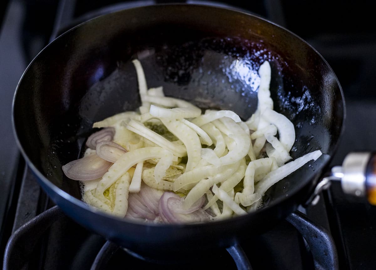 Cast iron with sliced shallots and fennel, cooked in butter.
