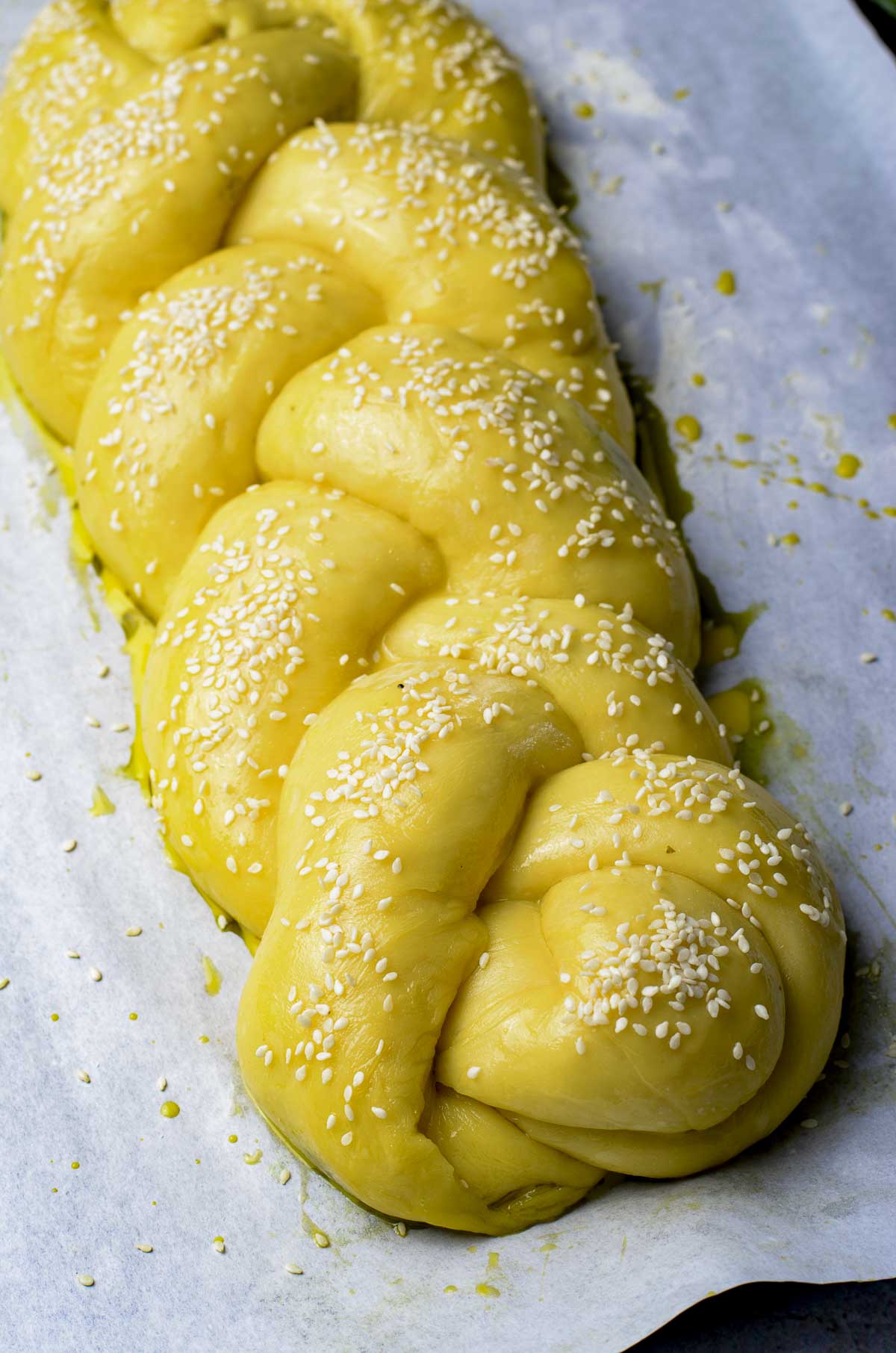 Challah bread dough braided and sprinkled with sesame seeds.
