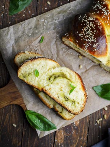 Sliced challah bread over a wooden serving board.