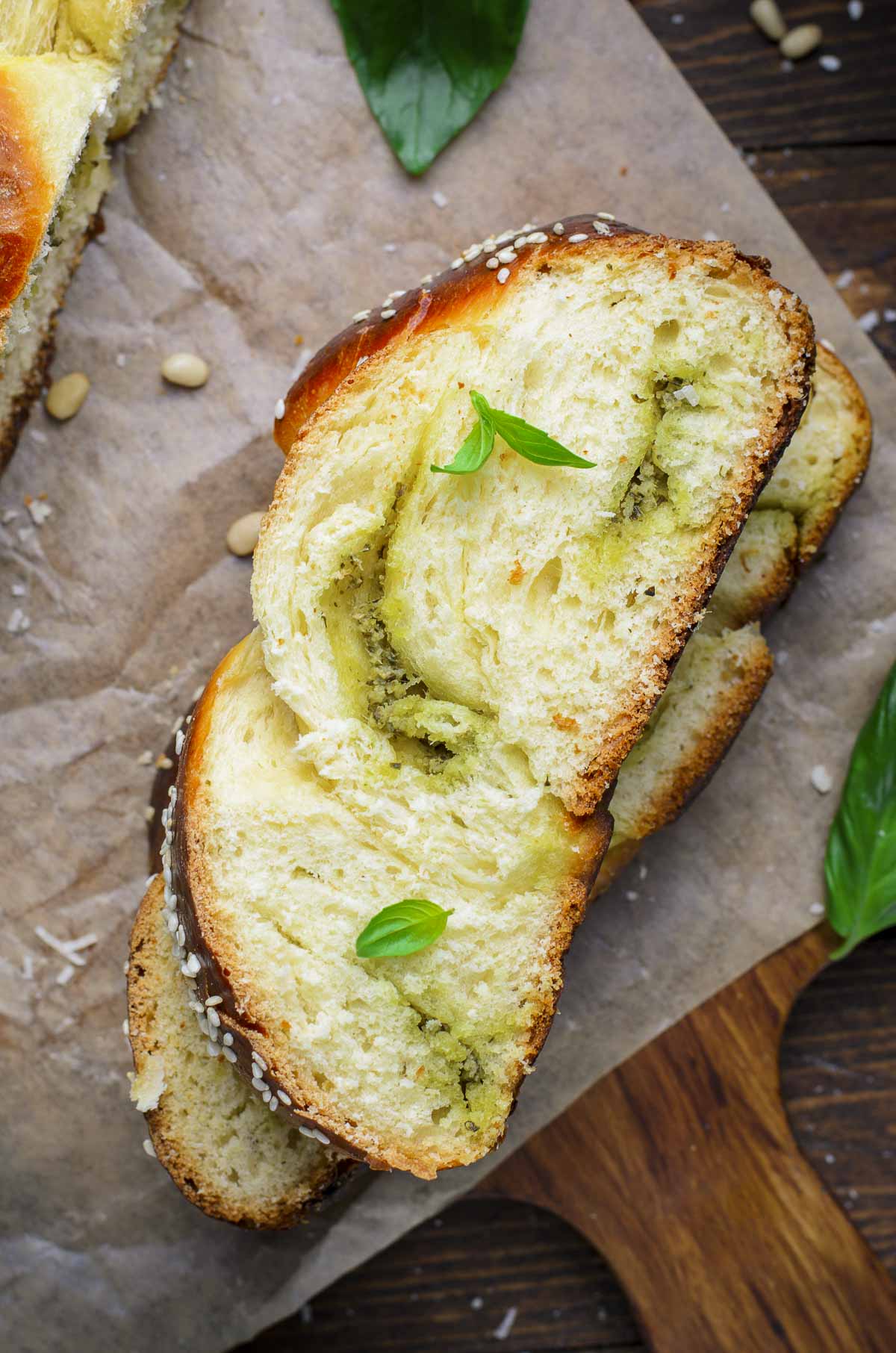 Close up of two sliced challah breads stacked on top of each other, with the pesto swirled into the dough.