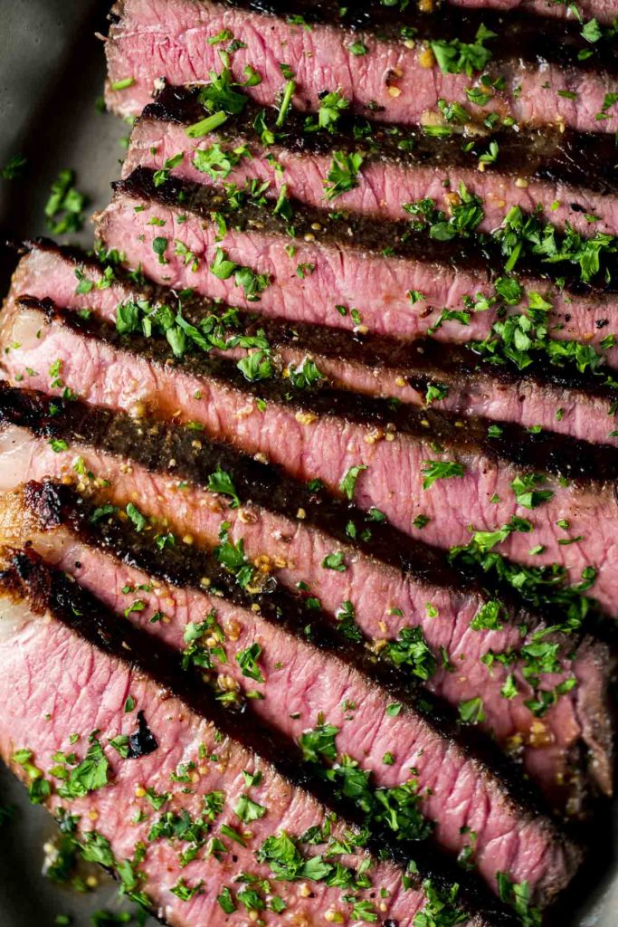 Up close of a London broil cooked to medium-rare and sliced.