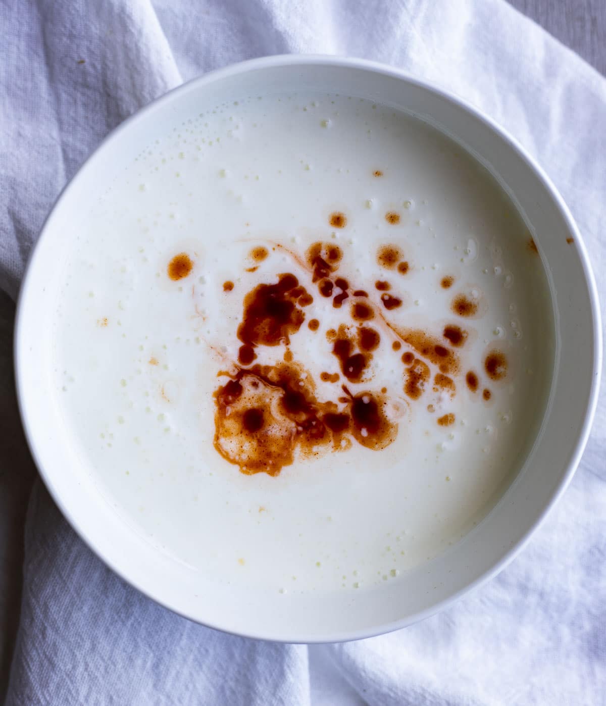 Buttermilk and hot sauce together in a bowl.