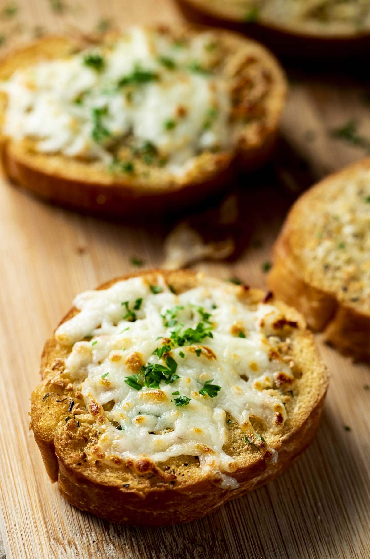 Side view of garlic bread topped with mozzarella cheese.