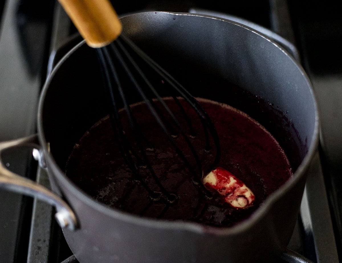 Butter being whisked into the blueberry curd.