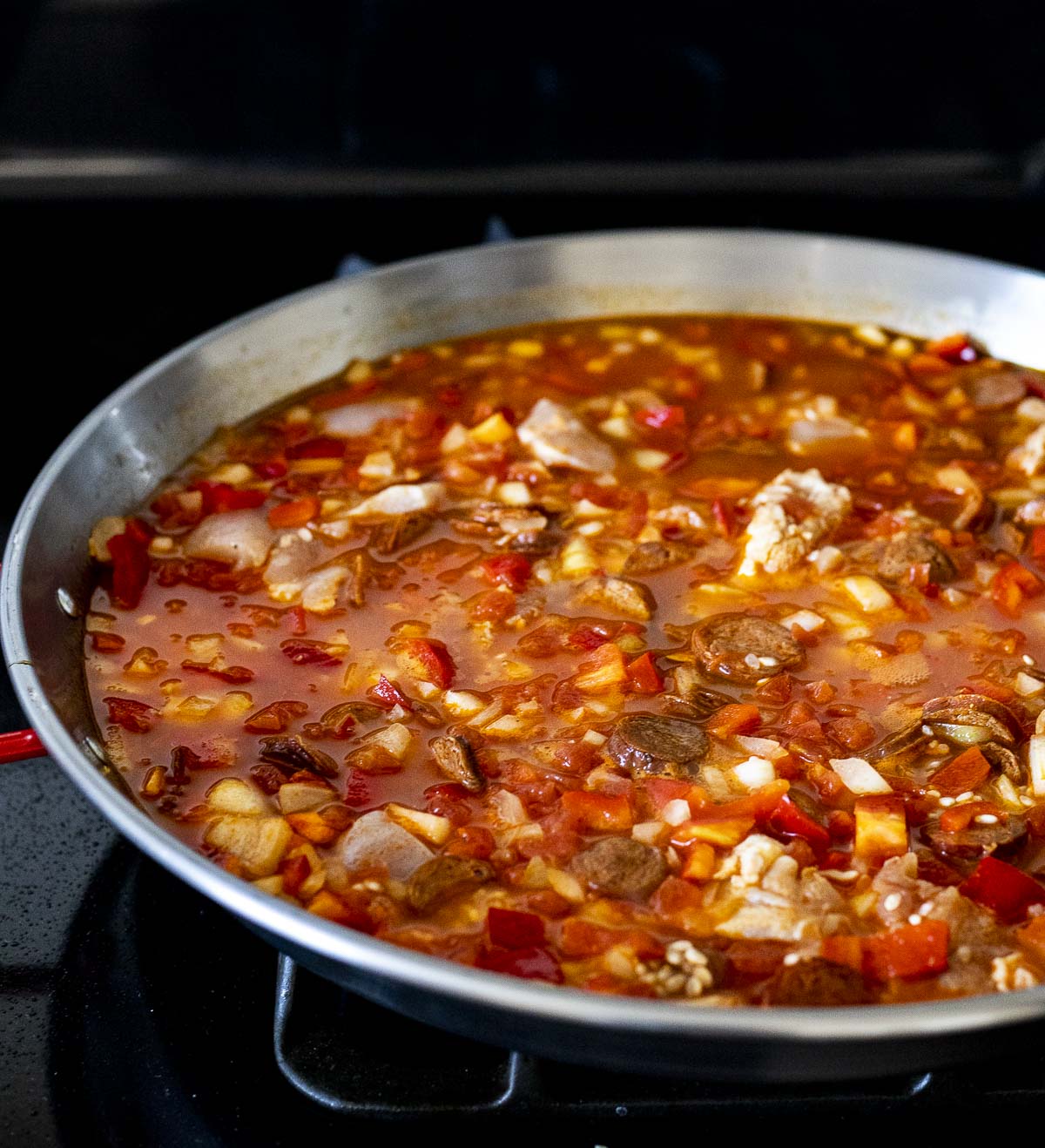Paella simmering in a pan.