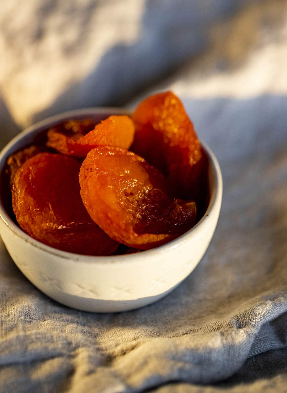Dehydrated apricot halves in a white dish.